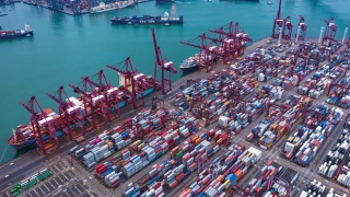 集装箱货轮在进出口业务和物流国际货物中的航拍折叠。由起重机在香港维多利亚港的晚上运往港口。视频素材模板下载