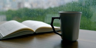 书和咖啡杯放在下雨天的木桌上
