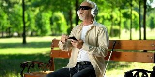 老盲人用耳机接电话，听语音信息，有声读物