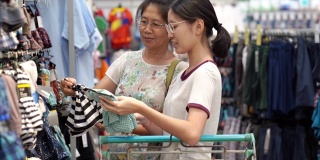 亚洲家庭母亲和十几岁的女孩喜欢在销售商店购物中心度假购物