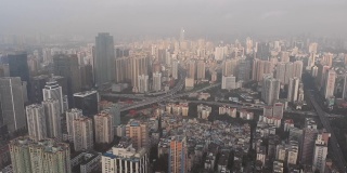 在日出的城市。摩天大楼占据了所有的空间，直到地平线，隐藏在雾霾中。广州,中国