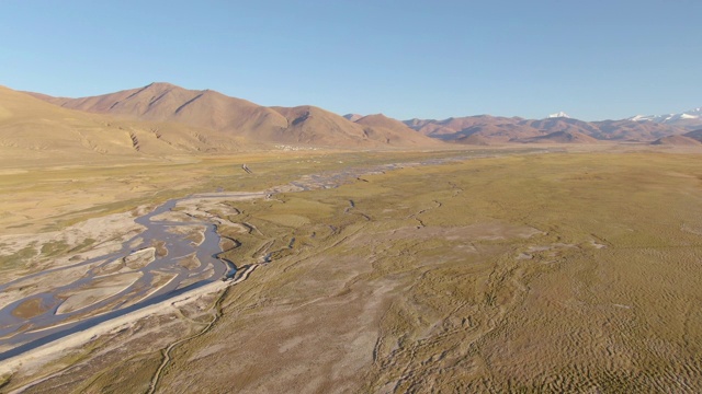 航拍:沿着流经喜马拉雅干旱平原的小溪飞行。