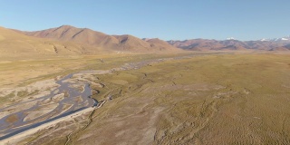 航拍:沿着流经喜马拉雅干旱平原的小溪飞行。