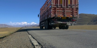 低角度:一辆旧卡车在通往珠穆朗玛峰的空旷道路上行驶。