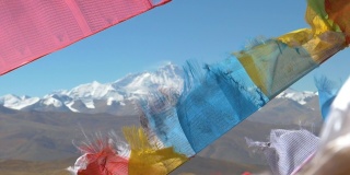 近距离观看，景深:在祈祷旗后面被冰雪覆盖的珠穆朗玛峰的壮观景象。