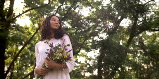 自然美少女带着一束鲜花在户外享受自由的理念