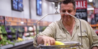 一位年长的拉丁裔男子在杂货店里购物，用秤称香蕉的重量。