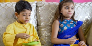 可爱的印度男孩在Raksha Bandhan节上给他的妹妹吃薯条