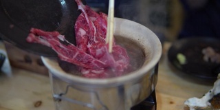 牛肉切片煮进涮锅。