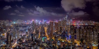 夜间，无人机在香港九龙人口密集的地区上空飞行，在孟角区有许多住宅建筑，背景是香港中部。