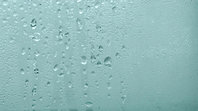 在玻璃窗上关上一个带雨滴的蒸汽镜，以雨季为背景