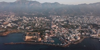 塞浦路斯北部Kyrenia市(Girne)的鸟瞰图，无人机从海岸移开，展示了港口、旧要塞和城市的美丽景色，无人机的平稳飞行