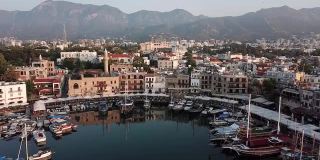 塞浦路斯北部Kyrenia市(Girne)的Kyrenia海港鸟瞰图。在群山和Kyrenia城堡的背景下，可以看到停泊着的游船、渔船和帆船。