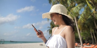 在海滩上玩智能手机的女人，度假