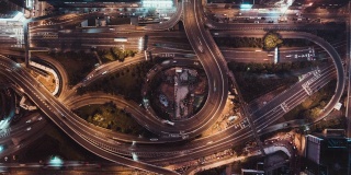 4K超高清俯视图延时在香港城市的多车道高速公路，蜿蜒的道路和回旋处的夜间汽车交通。通勤者，城市生活，或陆地交通概念。缩小的相机
