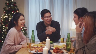 4K超高清:一群亚洲人围坐在桌边，在家里和朋友们一起吃饭、交流、玩乐。视频素材模板下载