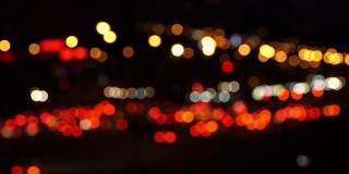模糊的交通堵塞的抽象色彩虚化，在夜晚城市的背景下十字路口汽车的移动前灯。
