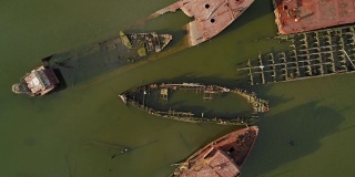 在美国纽约市史泰登岛的船墓地上沉没的生锈的废弃船只。向下看，正上方是无人机拍摄的航拍视频，伴随着旋转的摄像机运动。