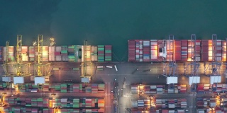 集装箱船夜间作业，远洋集装箱船经营国际进出口物流运输，鸟瞰图。