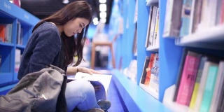 亚洲美丽的大学生在图书馆工作