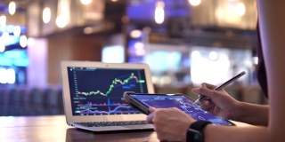 近距离女商人分析股票市场数据和工作在数字平板电脑