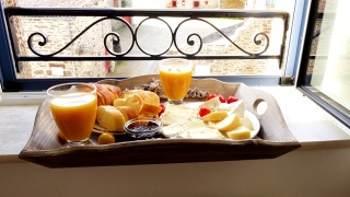 窗台上的法式早餐托盘。羊角面包，奶酪，果汁，果酱，圣女果和法棍面包视频素材模板下载