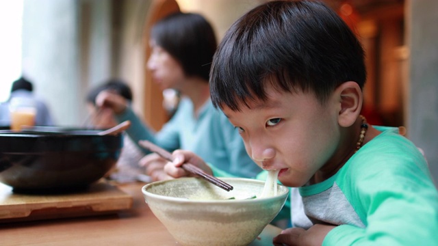 男孩用筷子吃米线