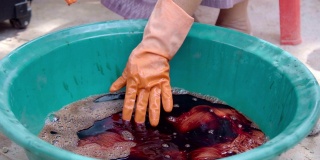 在泰国，妇女在用天然领带和染料纺织的火锅中煮织物。