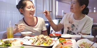亚洲家庭母亲和青少年吃日本食物寿司和健康的生活方式的健康食品