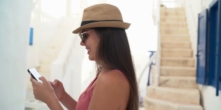 一名年轻女子在希腊米科诺斯镇使用智能手机
