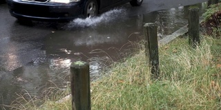 慢镜头里，汽车从雨坑里溅起水花