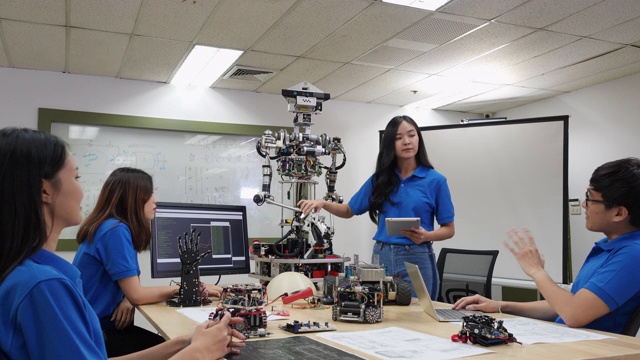 亚洲女性工程师目前机器人创新与建筑师设计团队在实验室。团队会议分享技术理念和协作开发机器人。表示机器人技术的概念。