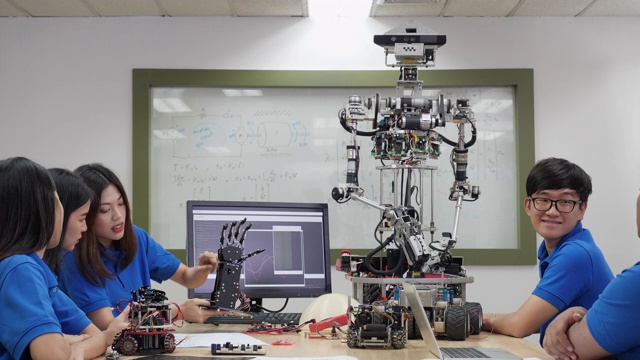 亚洲工程师团队在实验室组装和测试机器人反应。建筑师设计电路和工程师会议分享技术想法和协作开发机器人。