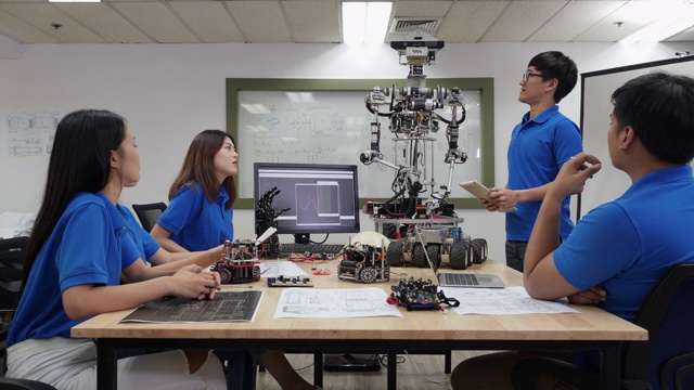 亚洲人工程师目前机器人创新与建筑师设计团队在实验室。团队会议分享技术理念和协作开发机器人。表示机器人技术的概念。