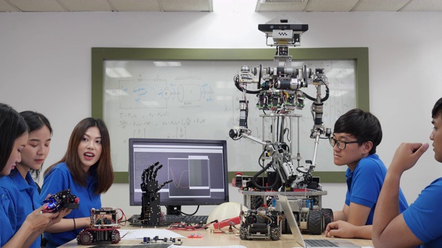 亚洲工程师团队在实验室组装和测试机器人反应。建筑师设计电路和工程师会议分享技术想法和协作开发机器人。