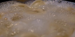 当饺子在锅里煮的时候，水里汩汩地冒着泡沫