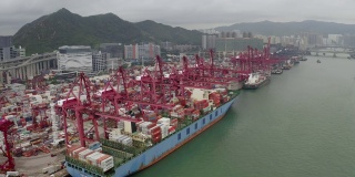 无人机航拍4k视频，在香港维多利亚港用起重机装运到港口。集装箱货船从事进出口业务和国际货物物流