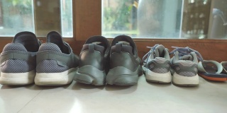 在家里门前，父亲的鞋和母亲的鞋紧挨着儿子的鞋的场景，家庭物品的概念