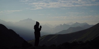 一个孤独的女性徒步旅行者在山顶喝咖啡
