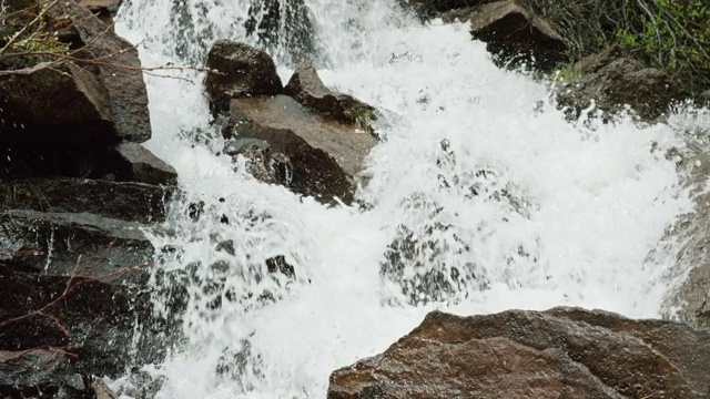 在慢镜头中，山涧的水从岩石和巨石上倾泻而下