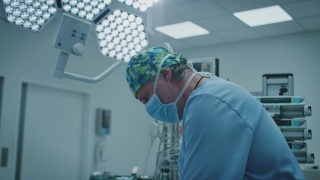 成熟的男性外科医生在ICU照明下手术视频素材模板下载