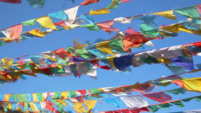 特写:在一个阳光明媚的日子里，电影镜头拍摄了西藏上空飘扬的旗帜