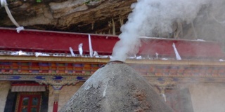 慢镜头:眼泪形状的燃烧器阴燃在前面的西藏寺院。