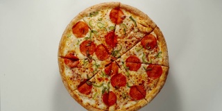 整个大披萨圈在一个白色的表面上旋转