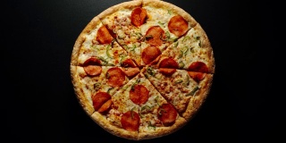 延时:大披萨的圆圈在一个黑色的表面上快速旋转