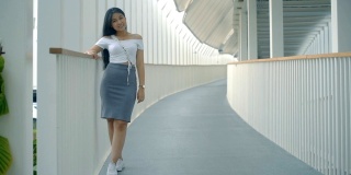 年轻的亚洲女性办公室职员在人行天桥