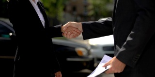 女商人与汽车经销商签约握手，购买汽车