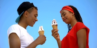 两名混血青少年正在大吃特吃甜筒冰淇淋