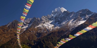 尼泊尔。绘有佛经的彩旗在强风中飘扬。背景是白雪覆盖的喜马拉雅山脉。UHD