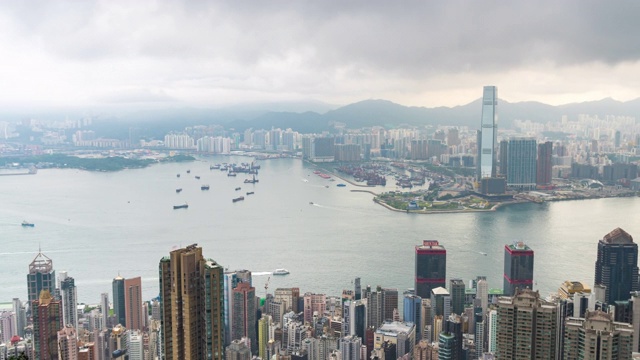时光流逝阴云密布的维多利亚湾和香港的建筑物基础设施-维多利亚港与现代化的商业建筑外区城市